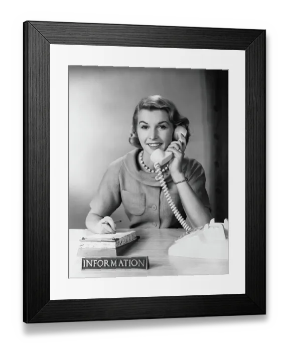 Framed Print : Female telephone receptionist at information desk, answering phone Framed Print : Female telephone receptionist at information desk, answering phone