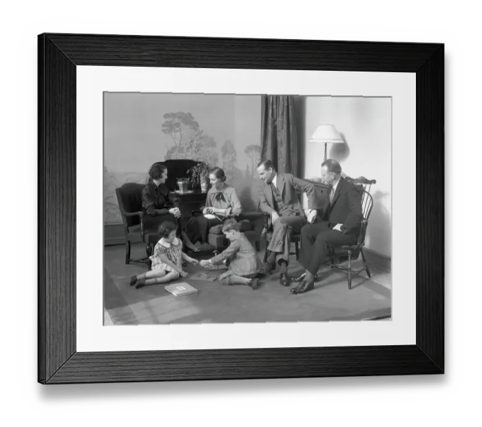 Framed Print : Family in living room daughter and son play on the floor mother and father talk to another couple Framed Print : Family in living room daughter and son play on the floor mother and father talk to another couple
