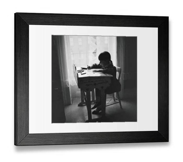Framed Print : Little girl silhouetted at window, sitting at desk, studying, urban view out of window Framed Print : Little girl silhouetted at window, sitting at desk, studying, urban view out of window