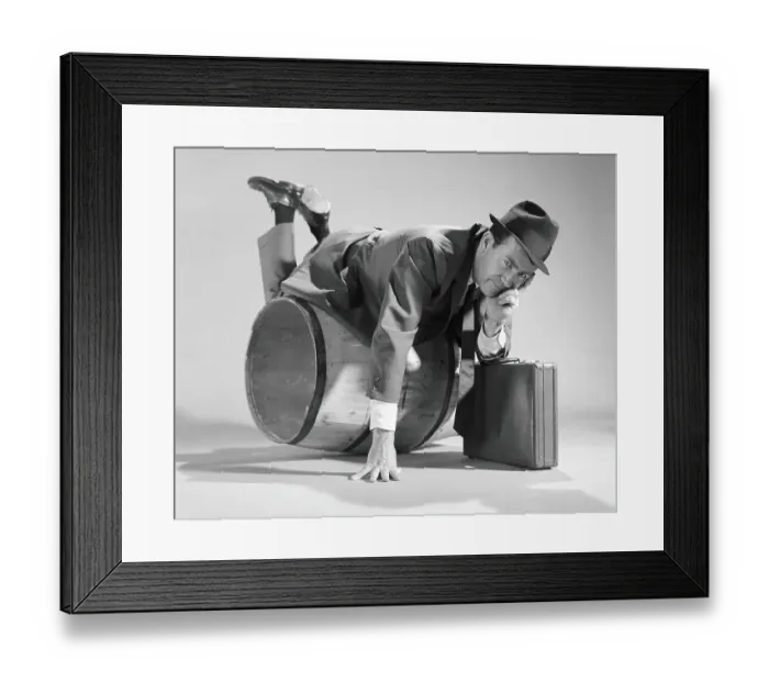 Framed Print : Businessman over a barrel, holding briefcase Framed Print : Businessman over a barrel, holding briefcase