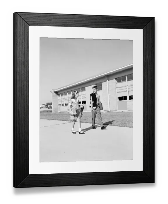 Framed Print : Boy and girl walking past school, carrying books and sweaters Framed Print : Boy and girl walking past school, carrying books and sweaters