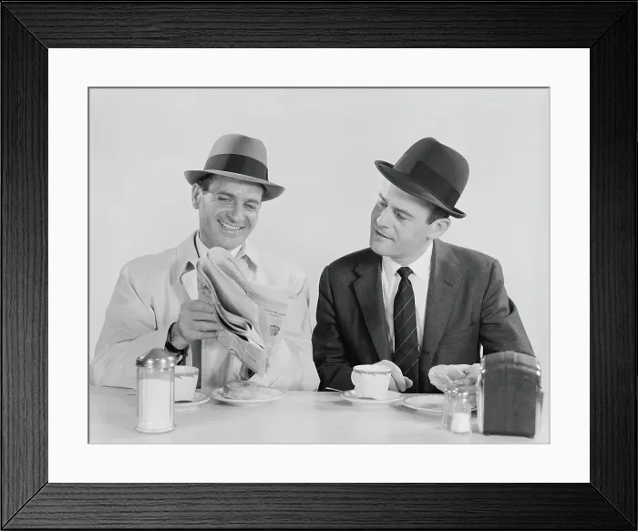 Framed Print : Two businessmen in suits and fedoras having breakfast at diner, looking at newspaper Framed Print : Two businessmen in suits and fedoras having breakfast at diner, looking at newspaper