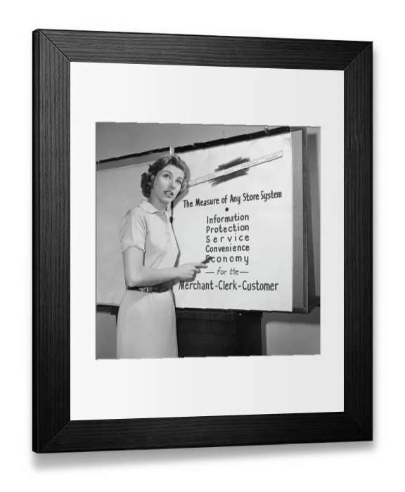 Framed Print : Young career woman giving business presentation, pointing at poster