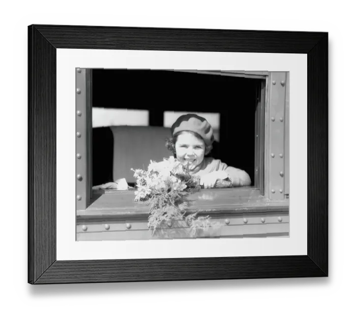 Framed Print : Girl on train, holding bouquet of flowers, wearing hat and jacket, smiling, looking out of window Framed Print : Girl on train, holding bouquet of flowers, wearing hat and jacket, smiling, looking out of window