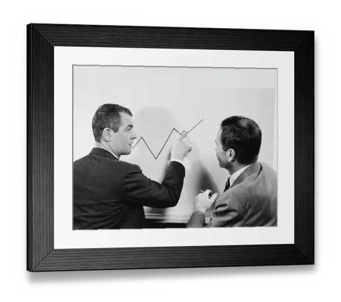 Framed Print : Two businessmen standing in front of chart graphic, pointing to line, peaks and valleys showing growth Framed Print : Two businessmen standing in front of chart graphic, pointing to line, peaks and valleys showing growth