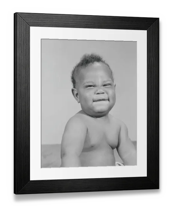 Framed Print : African-American baby squinting eyes and scrunching up face