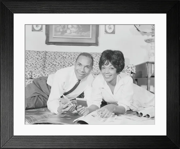 Framed Print : Couple going over house plans and color charts, smiling, portrait Framed Print : Couple going over house plans and color charts, smiling, portrait