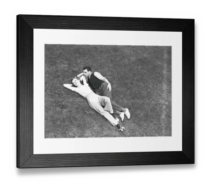 Framed Print : Couple lying on grass, (B&W), elevated view Framed Print : Couple lying on grass, (B&W), elevated view