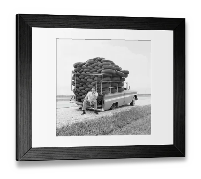 Framed Print : Flat Tire. A man experiences irony as his car Framed Print : Flat Tire. A man experiences irony as his car
