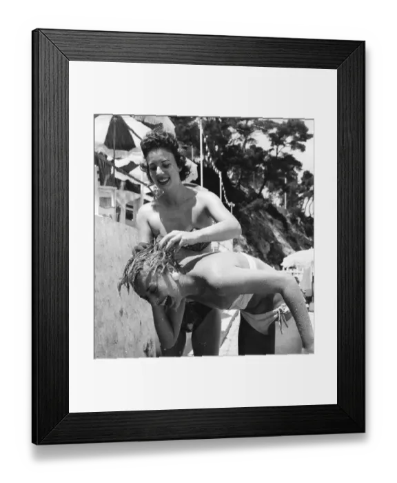 Framed Print : Hairwash. Picture Post model Jackie washes her friend's hair under a beach Framed Print : Hairwash. Picture Post model Jackie washes her friend's hair under a beach
