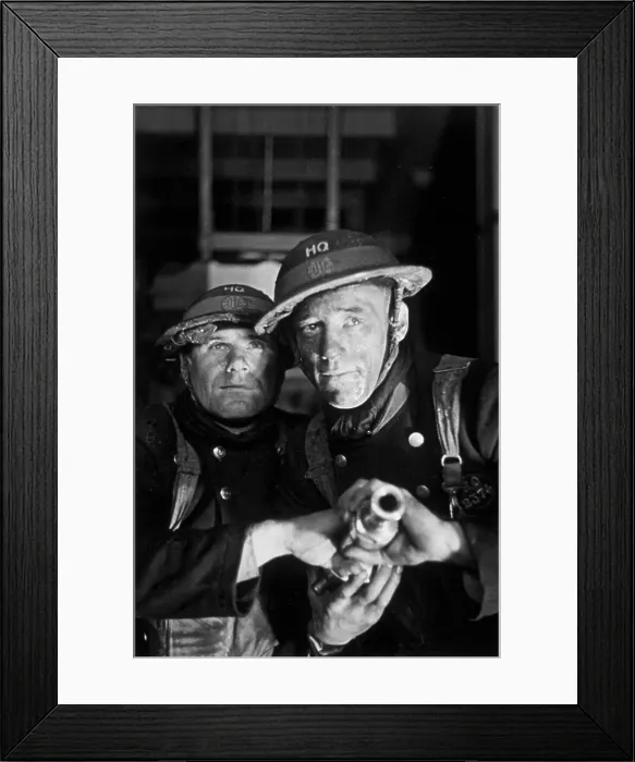 Framed Print : Firemen. 1st February 1941: Two firemen prepare to aim a hose at a blaze Framed Print : Firemen. 1st February 1941: Two firemen prepare to aim a hose at a blaze