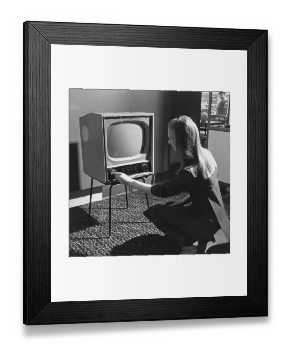 Framed Print : New TV. 1957: A woman tries a new television set Framed Print : New TV. 1957: A woman tries a new television set