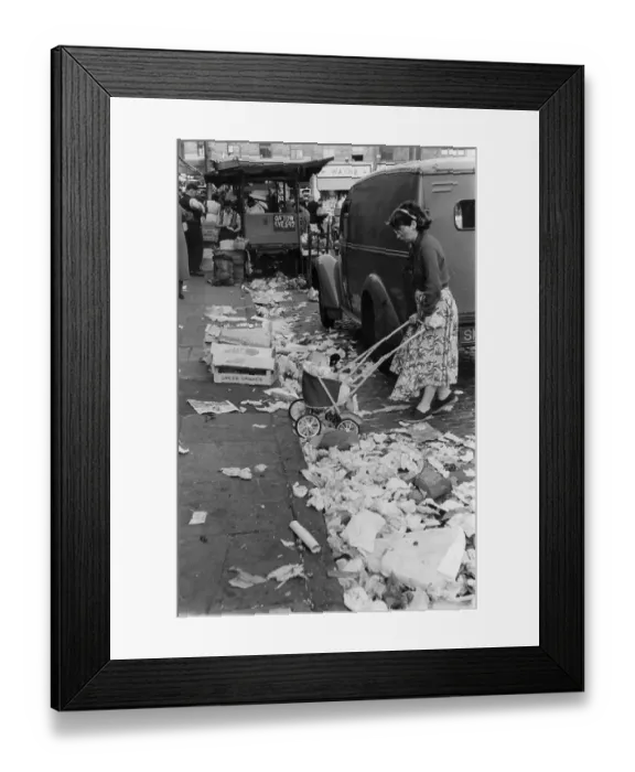 Framed Print : Litter. A woman propelling her baby in a pushchair through the piles of
