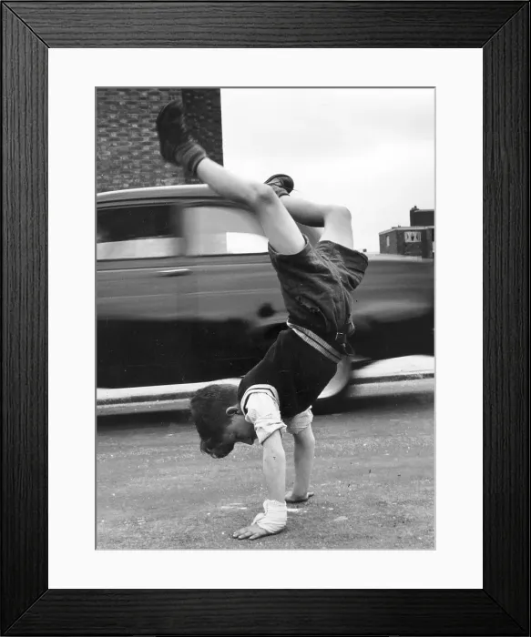 Framed Print : Handstand. A little boy doing a handstand in the road Framed Print : Handstand. A little boy doing a handstand in the road