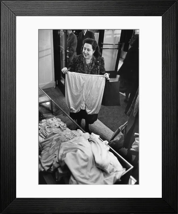Framed Print : Big Pants. A woman holding up a large pair of knickers at the opening of Framed Print : Big Pants. A woman holding up a large pair of knickers at the opening of