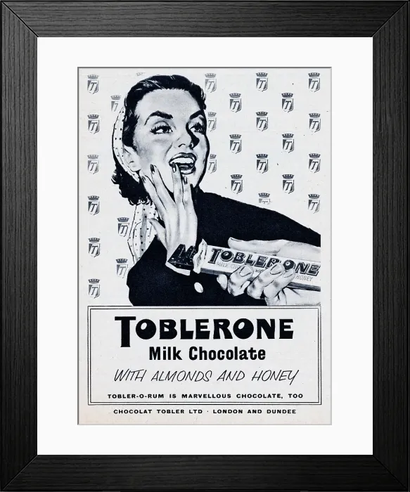 Framed Print : Toblerone. 1957: A man offers a woman a piece of a Toblerone chocolate bar Framed Print : Toblerone. 1957: A man offers a woman a piece of a Toblerone chocolate bar