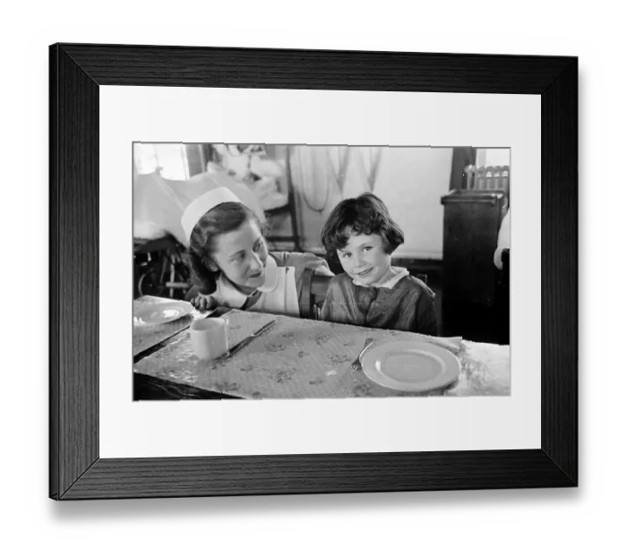 Framed Print : Teatime. 17th September 1955: A nurse sits a little girl down to table Framed Print : Teatime. 17th September 1955: A nurse sits a little girl down to table