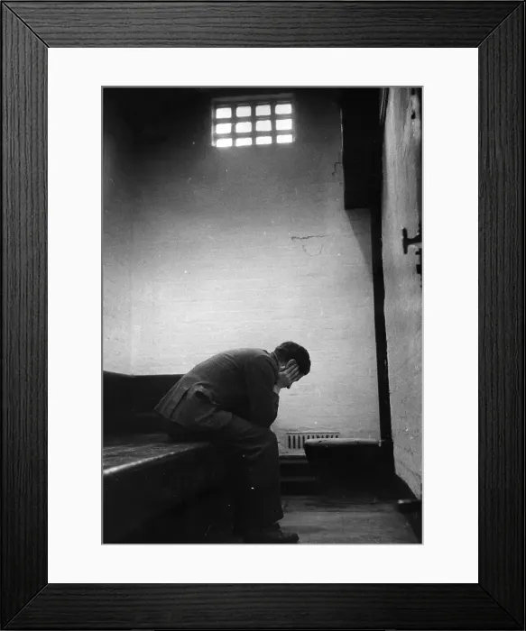 Framed Print : Prisoner. A prisoner sitting in his cell at a police station in Lancashire Framed Print : Prisoner. A prisoner sitting in his cell at a police station in Lancashire
