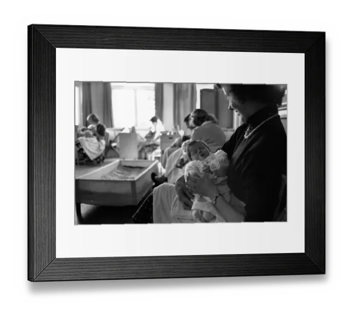 Framed Print : Happy Mum. 25th September 1954: An unmarried mother rocks her baby to sleep Framed Print : Happy Mum. 25th September 1954: An unmarried mother rocks her baby to sleep