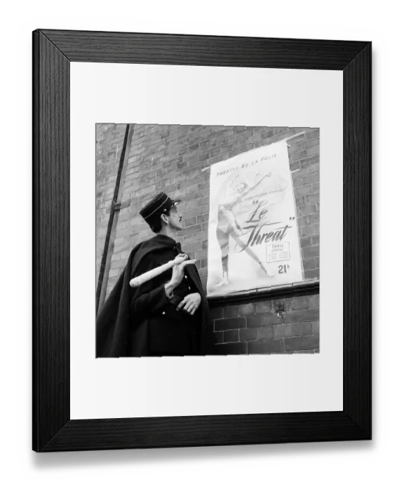 Framed Print : Le Threat. 3rd July 1954: A French official looking at a poster for a performance Framed Print : Le Threat. 3rd July 1954: A French official looking at a poster for a performance