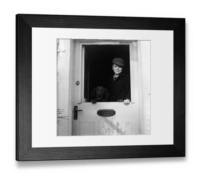 Framed Print : New Flats. 27th March 1954: A schoolboy and his dog standing at the saloon-type Framed Print : New Flats. 27th March 1954: A schoolboy and his dog standing at the saloon-type