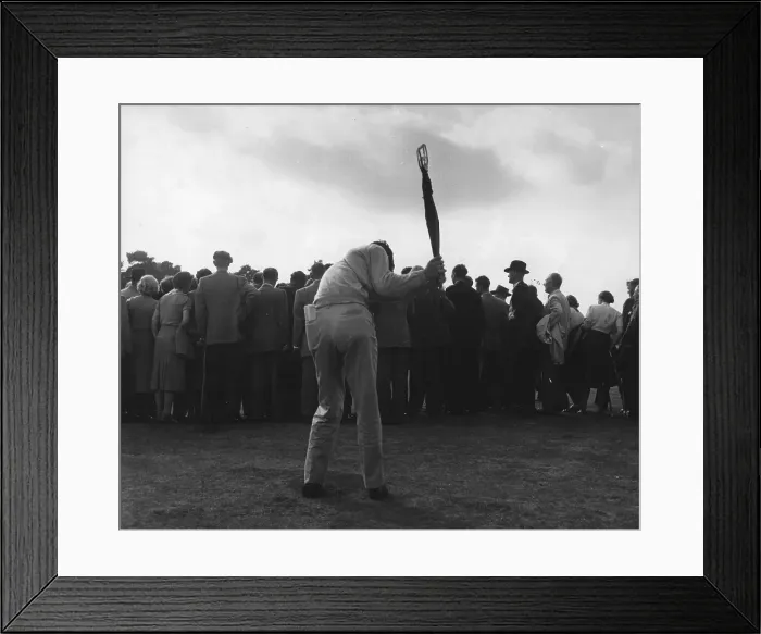 Framed Print : Golf Club. A crowd watching golf, whilst a man in the foreground practises Framed Print : Golf Club. A crowd watching golf, whilst a man in the foreground practises