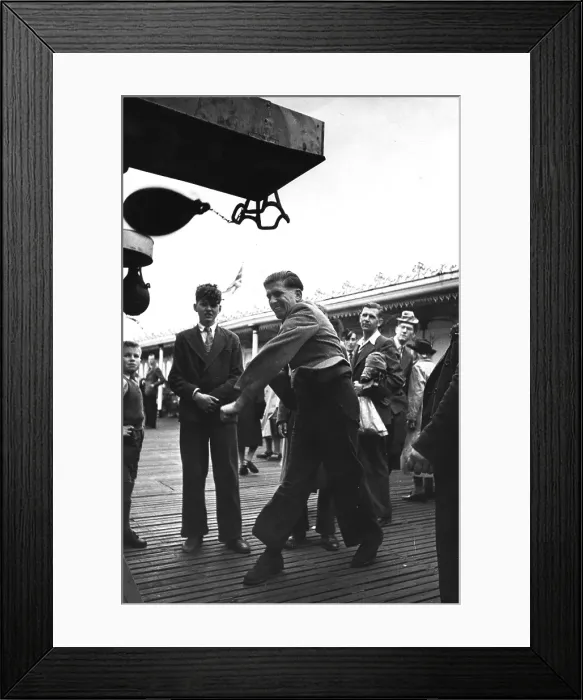 Framed Print : Punch Bag. A man pounds a punch bag on Brighton Pier Framed Print : Punch Bag. A man pounds a punch bag on Brighton Pier