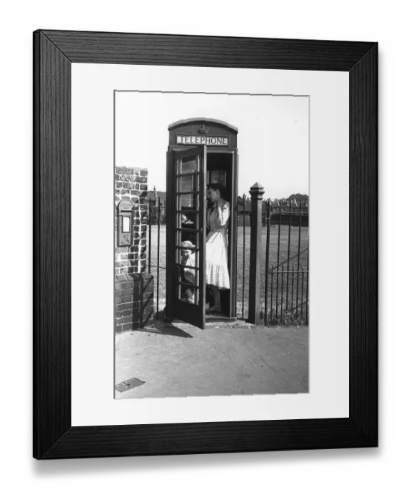 Framed Print : Phone Box. A woman and child in a telephone box Framed Print : Phone Box. A woman and child in a telephone box