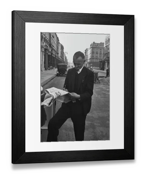 Framed Print : Hunted. A film crew member takes time out to complete the newspaper crossword Framed Print : Hunted. A film crew member takes time out to complete the newspaper crossword