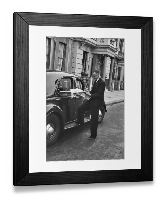 Framed Print : Hunted. A film crew member takes time out to complete the newspaper crossword Framed Print : Hunted. A film crew member takes time out to complete the newspaper crossword