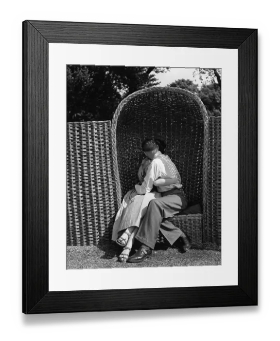 Framed Print : Love Seat. A couple kissing in one of the wicker alcove chairs at Battersea Framed Print : Love Seat. A couple kissing in one of the wicker alcove chairs at Battersea