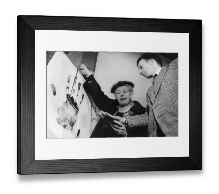 Framed Print : Palmistry. circa 1951: A palm reader holds up a blown-up image of a handprint Framed Print : Palmistry. circa 1951: A palm reader holds up a blown-up image of a handprint