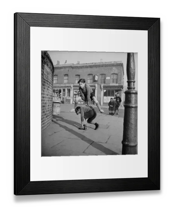 Framed Print : Leap Frog. A group of children playing leap frog in the street Framed Print : Leap Frog. A group of children playing leap frog in the street