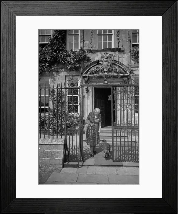 Framed Print : Walkies. 23rd July 1949: A woman leaves her house in Salisbury's Cathedral Framed Print : Walkies. 23rd July 1949: A woman leaves her house in Salisbury's Cathedral