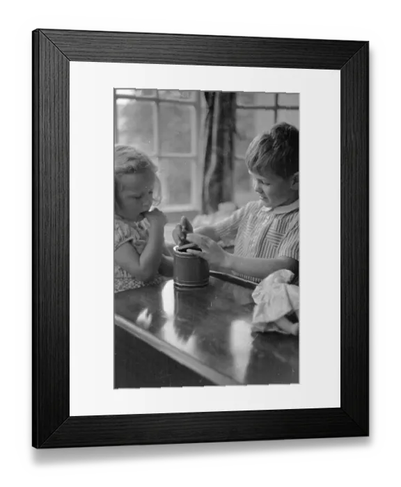 Framed Print : Music Box. 24th July 1948: Children playing with a tin can musical box Framed Print : Music Box. 24th July 1948: Children playing with a tin can musical box