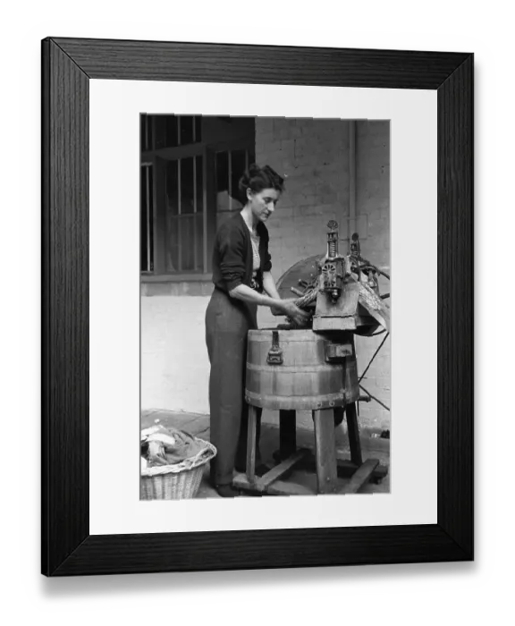 Framed Print : Wash Day. 7th September 1946: A woman wringing clothes through a mangle Framed Print : Wash Day. 7th September 1946: A woman wringing clothes through a mangle