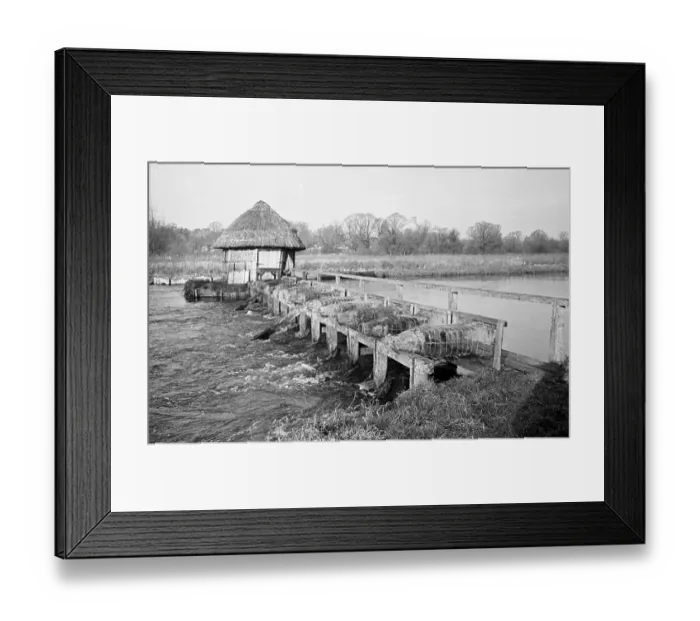Framed Print : Eel Trap. An eel trap with a walkway and a thatched hut spanning the River Test Framed Print : Eel Trap. An eel trap with a walkway and a thatched hut spanning the River Test