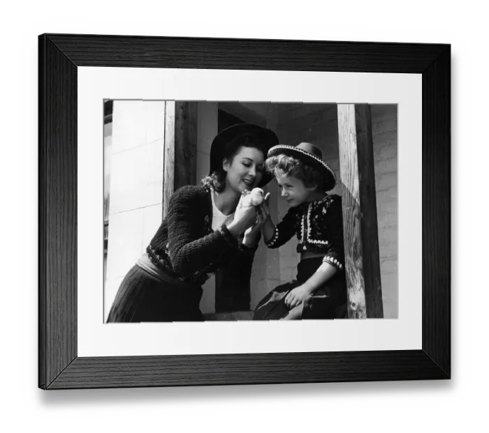 Framed Print : Chick. 30th August 1941: A mother holds a chick for her daughter to see Framed Print : Chick. 30th August 1941: A mother holds a chick for her daughter to see