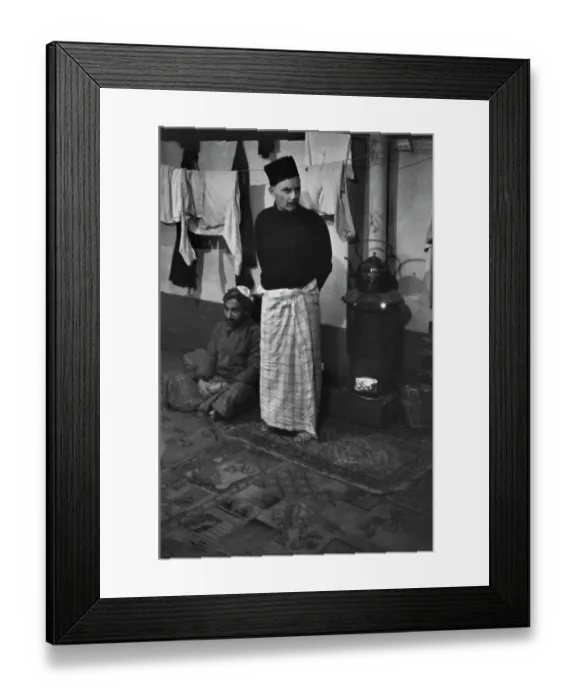 Framed Print : Cardiff. Two men warm themselves next to a wood-burning stove, Cardiff, 1939