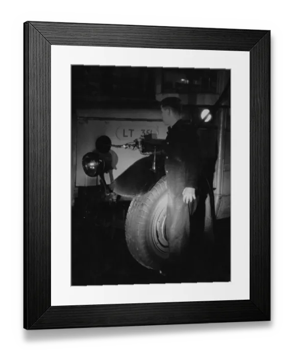 Framed Print : Oil Fill. A maintenance worker at a London bus garage tops up the oil on