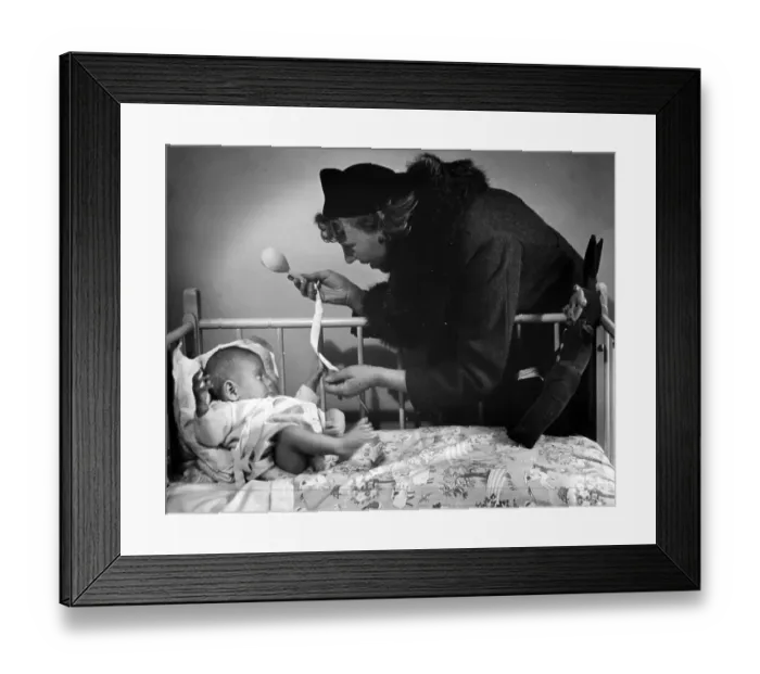 Framed Print : Playtime. 15th October 1938: A woman plays with a baby in a cot Framed Print : Playtime. 15th October 1938: A woman plays with a baby in a cot