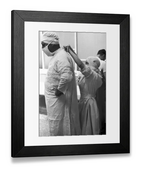 Framed Print : Tie Back. 1st October 1938: A nurse ties a surgeon's gown before an operation Framed Print : Tie Back. 1st October 1938: A nurse ties a surgeon's gown before an operation