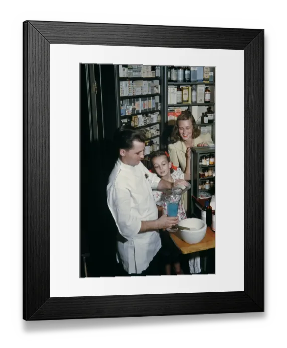 Framed Print : Pharmacy. NEW YORK - SEPTEMBER 1941: A Pharmacist prepares a prescription for a mother Framed Print : Pharmacy. NEW YORK - SEPTEMBER 1941: A Pharmacist prepares a prescription for a mother