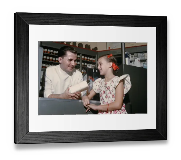 Framed Print : Pharmacy. NEW YORK - SEPTEMBER 1941: A Pharmacist serves a young girl in Framed Print : Pharmacy. NEW YORK - SEPTEMBER 1941: A Pharmacist serves a young girl in
