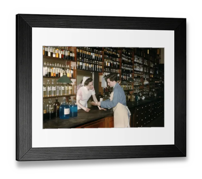 Framed Print : Pharmacy. NEW YORK - SEPTEMBER 1941: A Pharmacist consults with his assistant Framed Print : Pharmacy. NEW YORK - SEPTEMBER 1941: A Pharmacist consults with his assistant