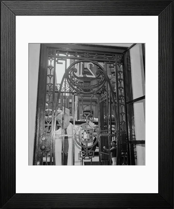 Framed Print : 21 Club. A caretaker closing the gate of the 21 Club, restaurant