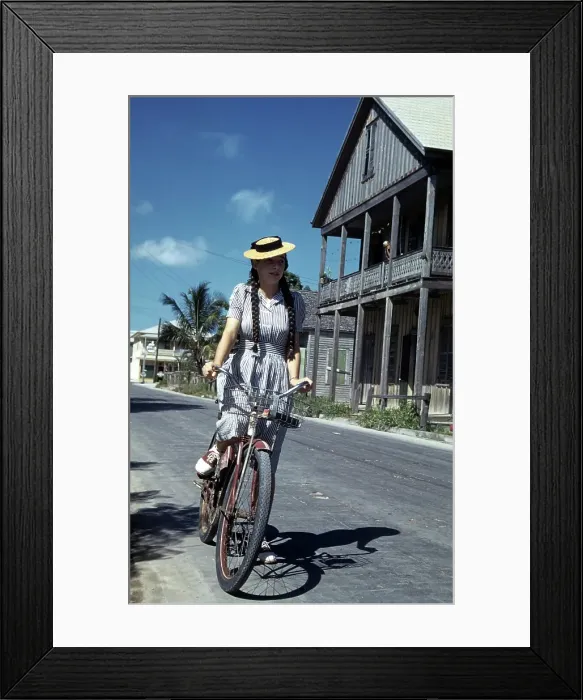 Framed Print : KEY WEST, FL - CIRCA 1946: A girl in a dress and straw hat rides her bike in Key West Framed Print : KEY WEST, FL - CIRCA 1946: A girl in a dress and straw hat rides her bike in Key West
