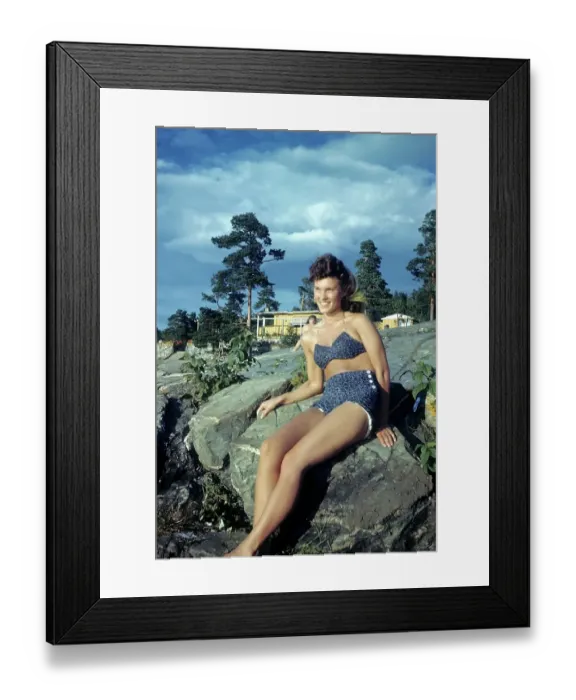 Framed Print : NORWAY - JULY 1946: A young women sunbathes on a rock in Norway Framed Print : NORWAY - JULY 1946: A young women sunbathes on a rock in Norway