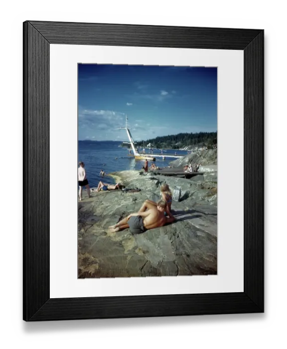 Framed Print : NORWAY - JULY 1946: A view as couples sunbathe on a rock in Norway Framed Print : NORWAY - JULY 1946: A view as couples sunbathe on a rock in Norway