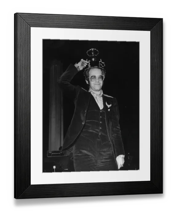 Framed Print : Crunk. CIRCA 1975: Pop singer Elton John holds up a fancy cup wearing a corduroy suit Framed Print : Crunk. CIRCA 1975: Pop singer Elton John holds up a fancy cup wearing a corduroy suit